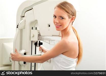 A young woman having taking a mammogram, looking at the camera