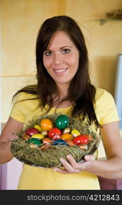 a young woman holds a cook with easter eggs in her hand