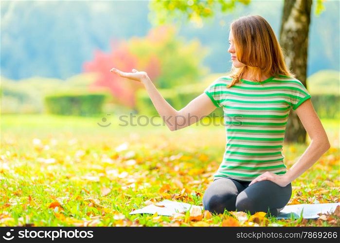 A young woman holds palm and looks at her