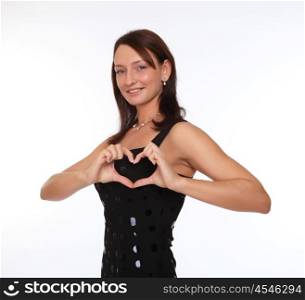 a young woman in a black evening dress showing a heart sign with her fingers