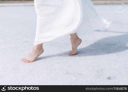 A young woman in a dress walks barefoot. A woman stands without shoes close up. A woman walks barefoot close up.. A young woman in a dress walks barefoot. A woman stands without shoes close up