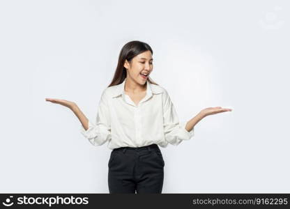 A young woman in a white shirt and spreading both her hands.