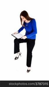 A young woman in black dress pants and a blue sweater is very angrytry to break her clip board, isolated for white background.