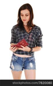A young woman in jeans shorts and a checker shirt looking in herGerman passport before the trip, for white background.