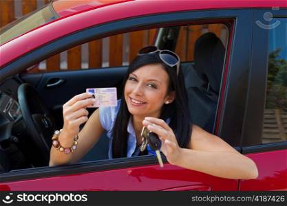 a young woman in the car with ingition. enjoying her driver&acute;s license