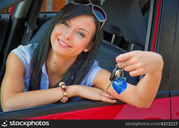 a young woman in the car with ingition. enjoying her driver&acute;s license