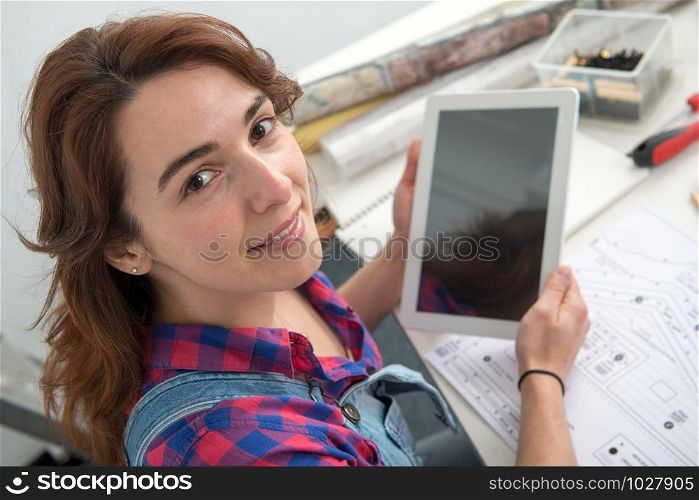 a young woman interior designer sitting at desk using digital tablet