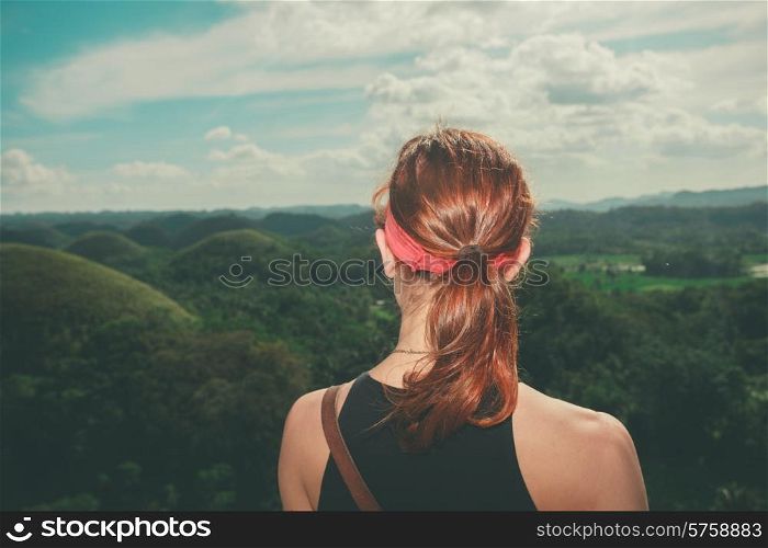 A young woman is admiring the view of the famous and unusual Chocolate hills in the Philippines