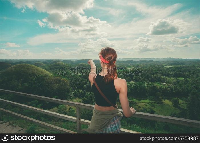 A young woman is admiring the view of the famous and unusual Chocolate hills in the Philippines