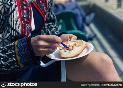 A young woman is eating a dressed crab outside on a sunny day