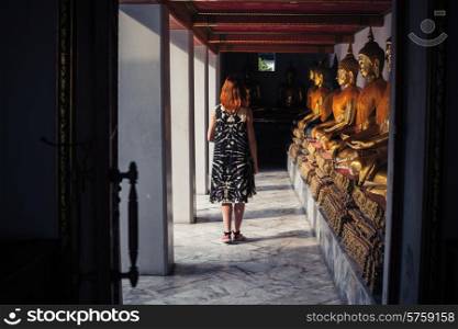 A young woman is exploring a buddhist temple