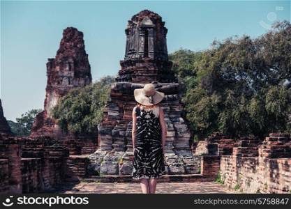 A young woman is exploring the ancient ruins of a buddhist temple city