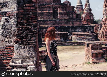 A young woman is exploring the ancient ruins of a buddhist temple city