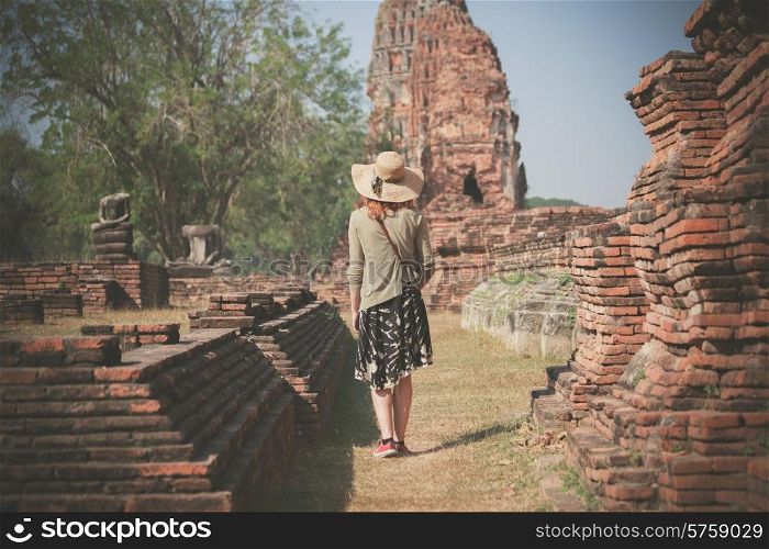 A young woman is exploring the ancient ruins of a buddhist temple city