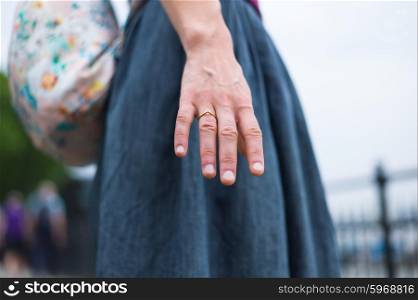 A young woman is extending her hand outside