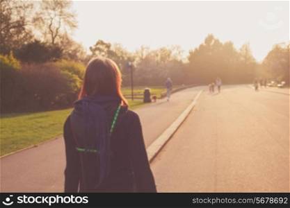 A young woman is looking at the sunset in the park