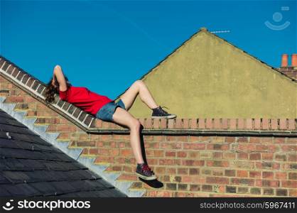 A young woman is lying on a rooftop and is relaxing