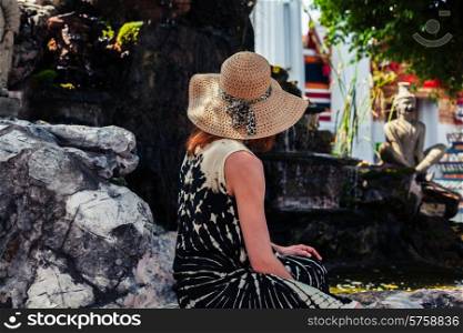 A young woman is relaxing in a buddhist temple garden