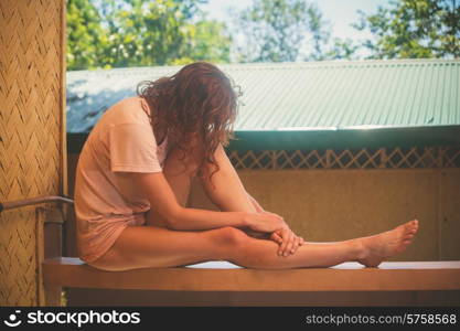 A young woman is relaxing on a porch in the tropics