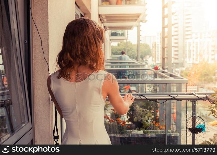 A young woman is relaxing on her balcony on a sunny day
