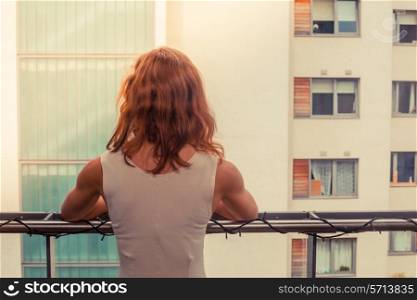 A young woman is relaxing on her balcony on a sunny day