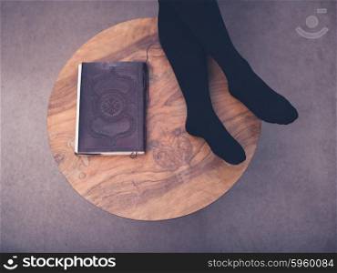 A young woman is resting her feet on a coffee table