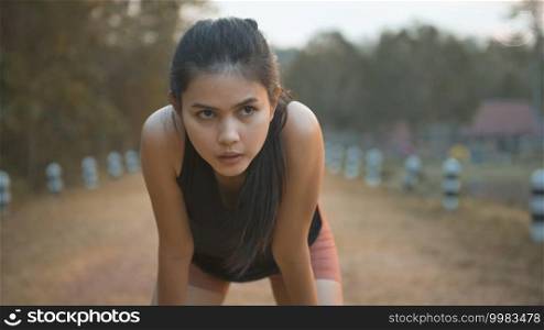 A young woman is running in nature outdoor at sunset