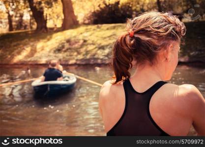 A young woman is sitting on the ground and relaxing by the water