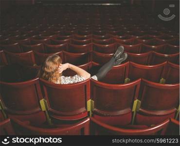 A young woman is talking on her phone in an auditorium