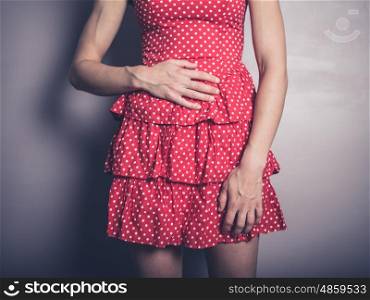 A young woman is touching her stomach because she has a belly ache