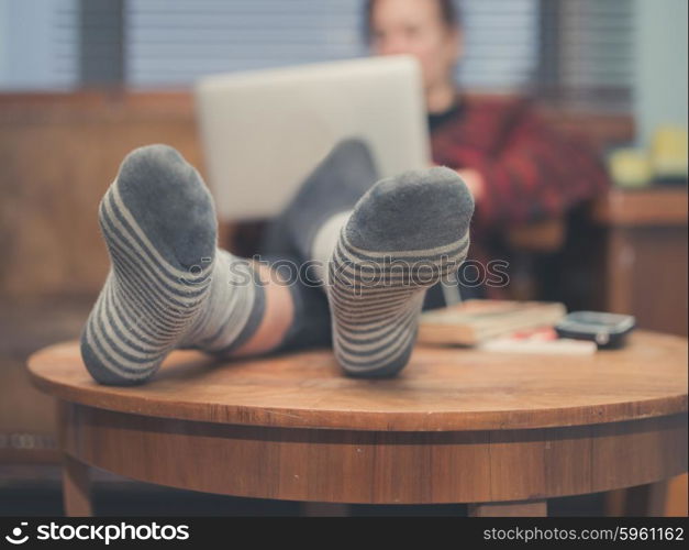 A young woman is using her laptop at home in her living room