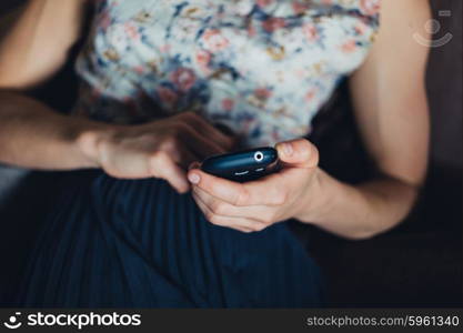 A young woman is using her smartphone at home