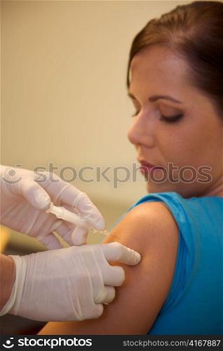 a young woman is vaccinated against the flu to a doctor