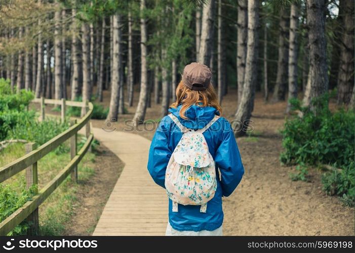 A young woman is walking alone in the forest