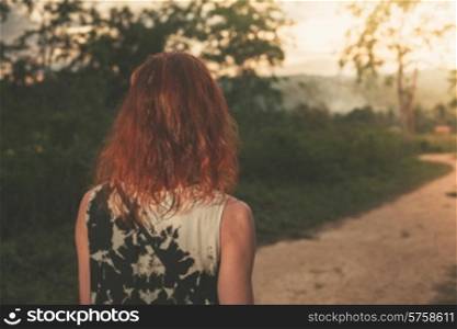 A young woman is walking around a farm in a tropical Asian country