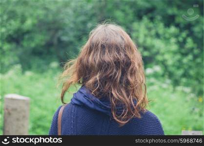 A young woman is walking in a green forest