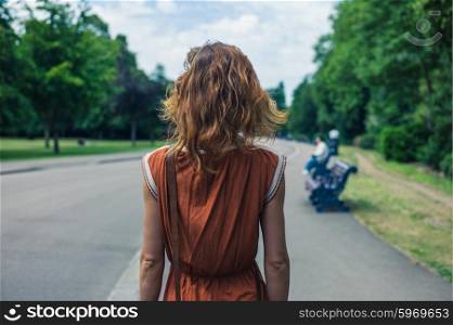 A young woman is walking in a park