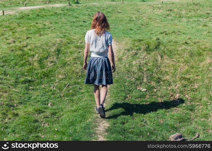A young woman is walking in the countryside