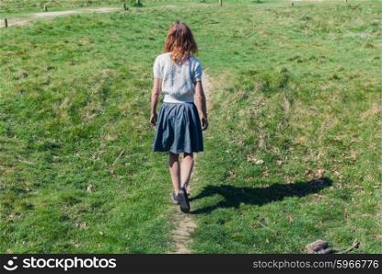 A young woman is walking in the countryside