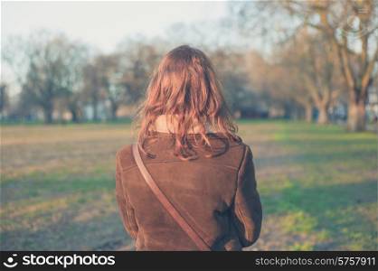 A young woman is walking in the park on a winter&rsquo;s day