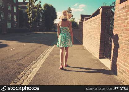 A young woman is walking in the street on a sunny day