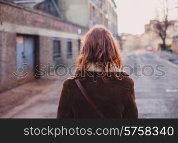 A young woman is walking on the quiet streets of a city in the winter