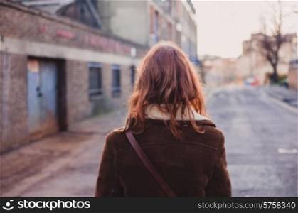 A young woman is walking on the quiet streets of a city in the winter
