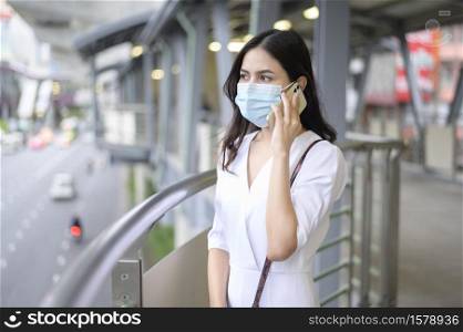 A young woman is wearing face mask in the Street city, Coronavirus protection, lifestyle under pandemic, Health care concept.. A young woman is wearing face mask in the Street city