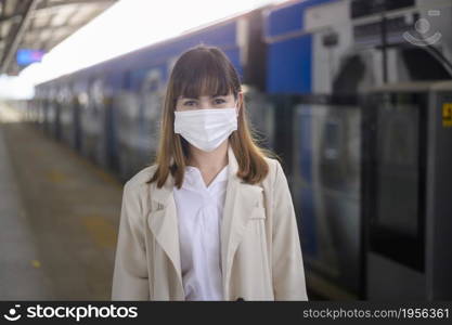 A young woman is wearing protective mask in metro , covid-19 protection , safety travel , new normal , social distancing , safety transportation , travel under pandemic concept. Young woman is wearing protective mask in metro , covid-19 protection , safety travel , new normal , social distancing , safety transportation , travel under pandemic concept