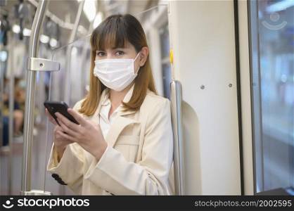 A young woman is wearing protective mask in metro , covid-19 protection , safety travel , new normal , social distancing , safety transportation , travel under pandemic concept. Young woman is wearing protective mask in metro , covid-19 protection , safety travel , new normal , social distancing , safety transportation , travel under pandemic concept