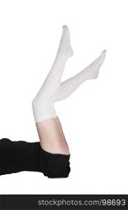 A young woman lying on the floor in a black dress and white long sockswith her legs straight up, isolated for white background