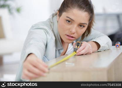 a young woman measuring wood