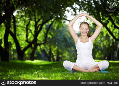 A young woman meditating in park