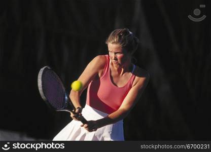 A young woman playing lawn tennis